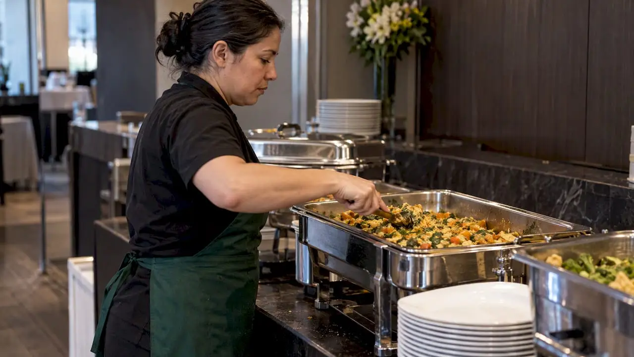 Attendant replenishes a full-size vegetarian entrée